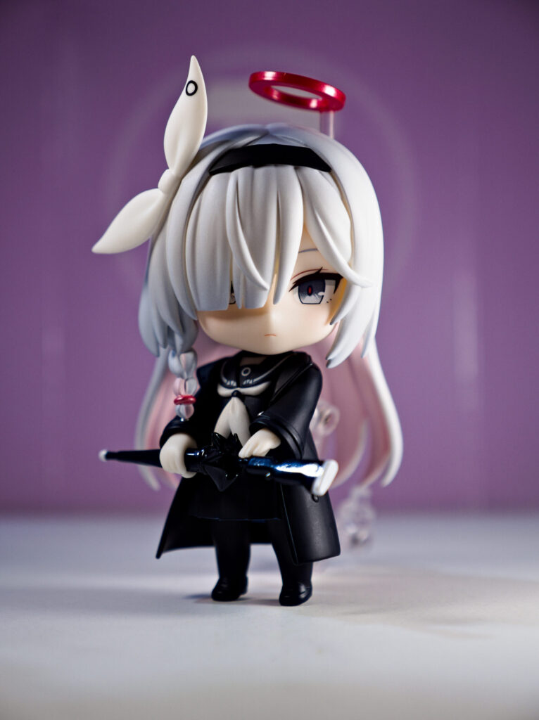 An image of a nendoroid girl with white hair and a black outfit with link text leading to the next page